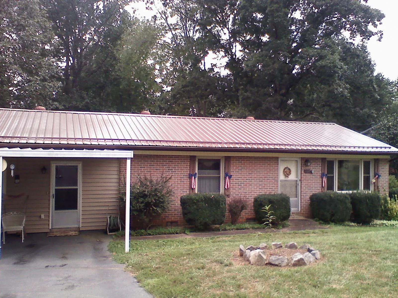 Bronze metal roof and carport on a brick ranch home — Roof Repair work by our crew in Spanish Fork